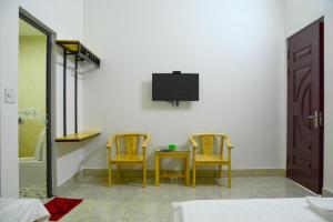 a bedroom with two chairs and a table and a tv at Nhà Nghỉ Ngọc Long in Mộc Châu +46 photos