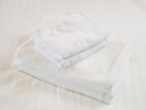 a stack of white towels sitting on a table at Hotel Cuore Kokusai Dori Naha in Naha +55 photos