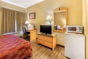 a hotel room with a bed and a television at Econo Lodge Airport/Colorado Springs in Colorado Springs