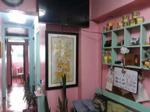 Habitación rosa con una foto en la pared en CV Bed n Bath, en Baguio