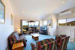 a living room with two couches and a television at Lorne Ocean Sun Apartments in Lorne