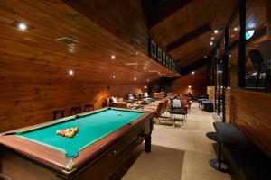 a pool table in a room with wooden walls at Breathtaker Hotel and Spa in Mount Buller