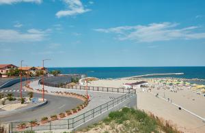 a beach with umbrellas and people on the beach at Gabizz Apartments in Constanţa