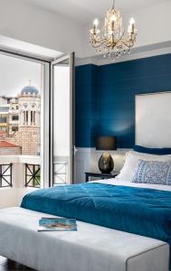 a blue bedroom with a bed and a chandelier at Evripidou Suites in Athens