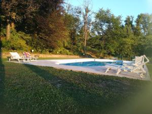 a swimming pool with two chairs and a picnic table next to it at La Giorgetta in Ovada