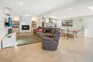 sala de estar con sofá, mesa y cocina en Easy Living Bayside Accommodation en Tootgarook