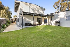 an open backyard with a lawn in front of a house at Easy Living Bayside Accommodation in Tootgarook