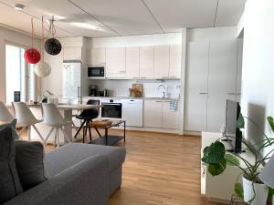 cocina y sala de estar con sofá y mesa en The Harbour Apartments en Jyväskylä