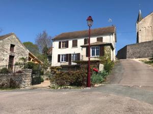 a red street light in front of a white house at Gîte Pierre et Marie in Mellecey