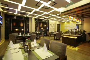a dining room with tables and chairs in a restaurant at ​juSTa Gurgaon in Gurgaon