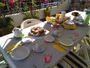 a table with plates and cups and food on it at La Castellese in Aci Castello
