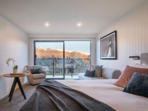 um quarto com uma cama e vista para as montanhas em Kamana Lakehouse em Queenstown