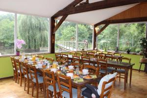 een eetkamer met tafels, stoelen en ramen bij Moulin de Bray - Chambres d'hotes et hébergement Insolite in Vieux-Vy-sur-Couesnon