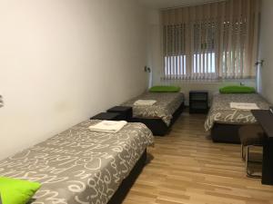Habitación con 3 camas con almohadas verdes. en Pension Haus Baron 4 Mühlheim, en Mühlheim am Main