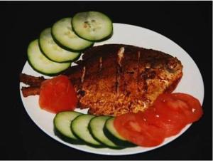 a plate of food with meat and cucumbers and tomatoes at Ballaleshwar cottage in Alibaug