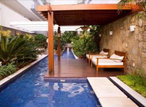 una piscina con terraza de madera y una piscina en Mandai 02 suítes apt 101 MC temporadas, en Cabo Frío