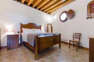 een slaapkamer met een bed en een stoel in een kamer bij Medieval Relais - Top location in Montagnana