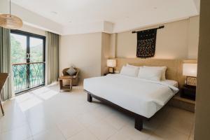 a bedroom with a large bed and a large window at Bintang Flores Hotel in Labuan Bajo
