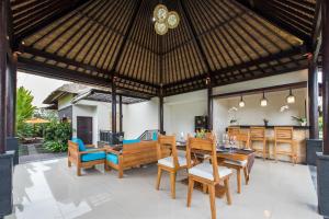 een eethoek in de openlucht met een tafel en stoelen bij Villa Cendrawasih Ubud in Tegalalang