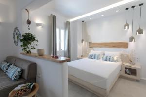 a white bedroom with a bed and a couch at HORA SUITES in Naxos Chora