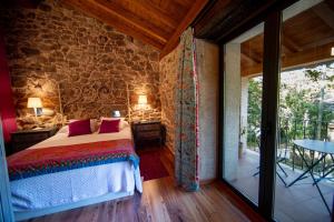 um quarto com uma cama e uma parede de pedra em Casa de Anamá em Entrecinsa