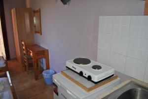 a kitchen with a stove on top of a refrigerator at Magdalini Studio in Anaxos
