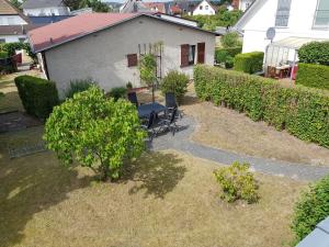 einen Garten mit einem Tisch und Stühlen vor einem Haus in der Unterkunft Ferienwohnungen im Haus Bi Henny in Baabe