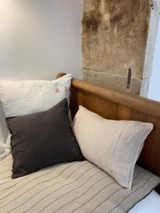 een bed met een houten hoofdeinde en 2 kussens bij L'Autre Maison in Bozouls
