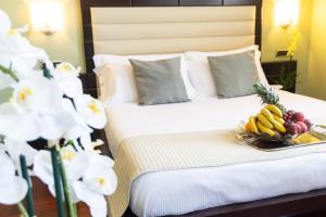 Una cama con un plato de fruta y flores. en Hotel Silver Milano, en Milán 37 fotos más