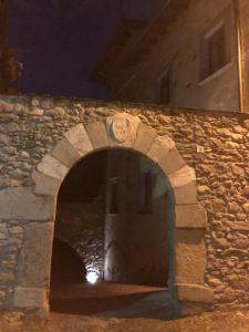 un arco in un muro di pietra di notte di Hotel Albrici a San Bernardo