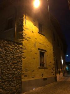 a yellow building with a window at night at Hotel Albrici in Ponte in Valtellina