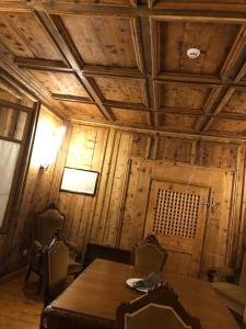 una sala da pranzo con tavolo e soffitto in legno di Hotel Albrici a San Bernardo