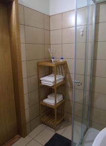 a bathroom with a shower and towels on a shelf at Cantinho Das Estrelas, Luz Lagos in Luz