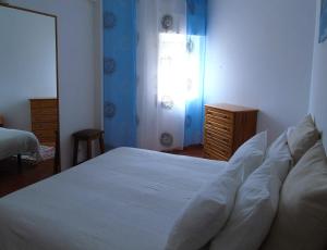 a bedroom with a white bed and a window at Cantinho Das Estrelas, Luz Lagos in Luz
