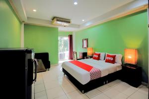 a bedroom with a bed and a green wall at OYO 254 Royal Pimand in Bangkok