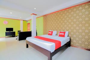 a bedroom with a large bed with red pillows at OYO 254 Royal Pimand in Bangkok