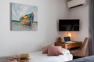 a room with a bed and a desk with a laptop and an umbrella at Adriatic Apartment in Dubrovnik