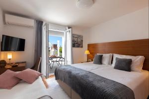 a hotel room with two beds and a balcony at Adriatic Apartment in Dubrovnik