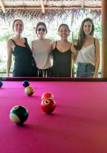 a group of three women standing next to a pool table at Riva del Sole Guest House in Arugam Bay