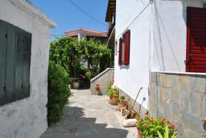 an alley between two white buildings with red shutters at Magdalini Studio in Anaxos