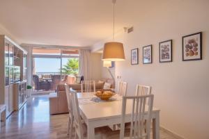 a dining room and living room with a table and chairs at Edificio Magna Marbella in Marbella