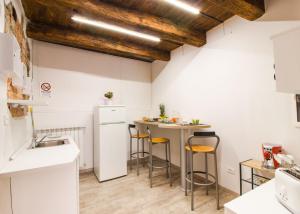 a kitchen with white cabinets and a small table with stools at Loft & Espace Maison 1706 Lago Orta in Borgomanero