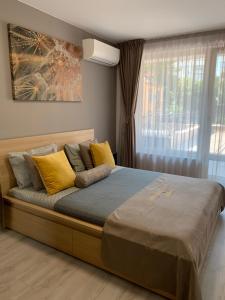 a large bed with yellow pillows in a bedroom at Kapana Luxury City Center Apartments with Garage in Plovdiv