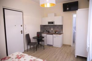 a kitchen with a table and a small kitchen with white cabinets at Ludovica Home in Giardini Naxos