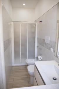 a bathroom with a shower and a toilet and a sink at Ludovica Home in Giardini Naxos