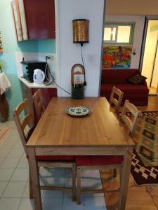 a wooden table with chairs and a plate on it at הבית הירוק - Green House in Arad