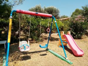 a playground with two swings and a slide at Locazione Turistica Casa in Campagna in Reggio Calabria