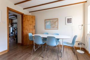 ein Esszimmer mit einem weißen Tisch und blauen Stühlen in der Unterkunft Selah Cottage, 21 Queen Street in Pont-rhyd-y-fen