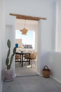 a dining room with a table and chairs and a cactus at HORA SUITES in Naxos Chora