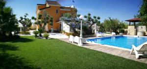 un cortile con piscina e una casa di Villa Iris a Castellana Grotte